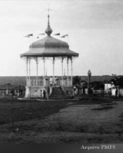 Reforma da Praça Fróes da Mota coloca patrimônio histórico no centro das atenções

Coreto de 1919 reúneReforma da Praça Fróes da Mota coloca patrimônio histórico no centro das atenções ladrilhos hidráulicos, ferro trabalhado e elementos ecléticos; praça conserva ainda peça de iluminação pública datada de 1903

A Praça Eduardo Fróes da Mota, no centro de Feira de Santana, será totalmente reformada após ordem de serviço assinada nesta quarta-feira (26) pelo prefeito José Ronaldo de Carvalho. A intervenção receberá investimento de R$ 852.585,37 e terá prazo previsto de quatro meses. Entre os cuidados anunciados está a manutenção das características originais do coreto histórico, construído no início do século XX e um dos principais elementos arquitetônicos preservados no espaço.